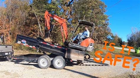 loading a mini excavator into a dump truck|dump trailer loading.